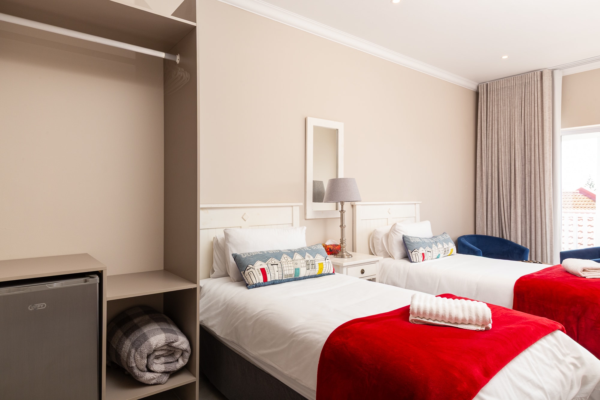 Modern hotel room twin beds with red blankets