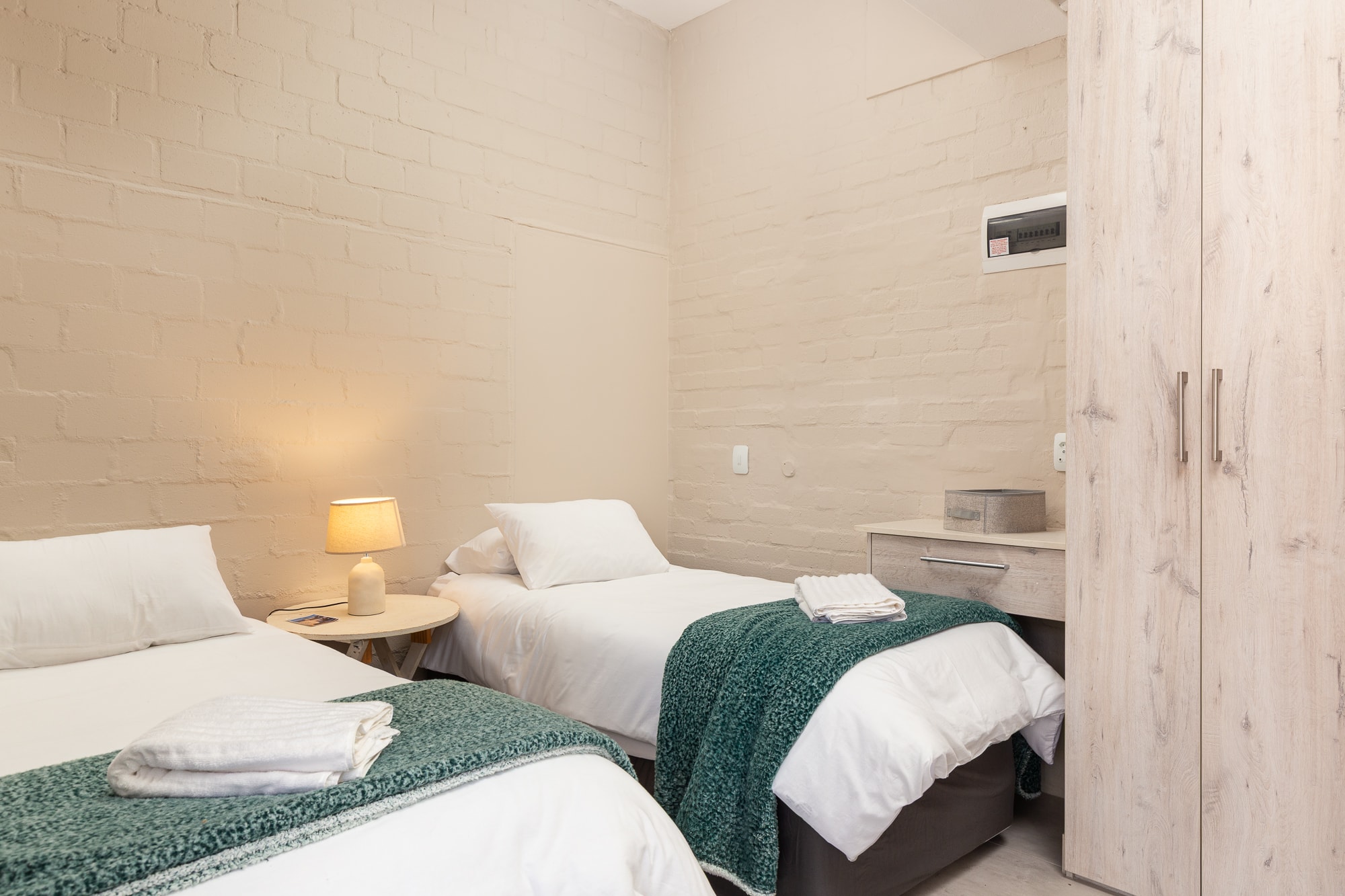 Modern hotel room twin beds with green blankets