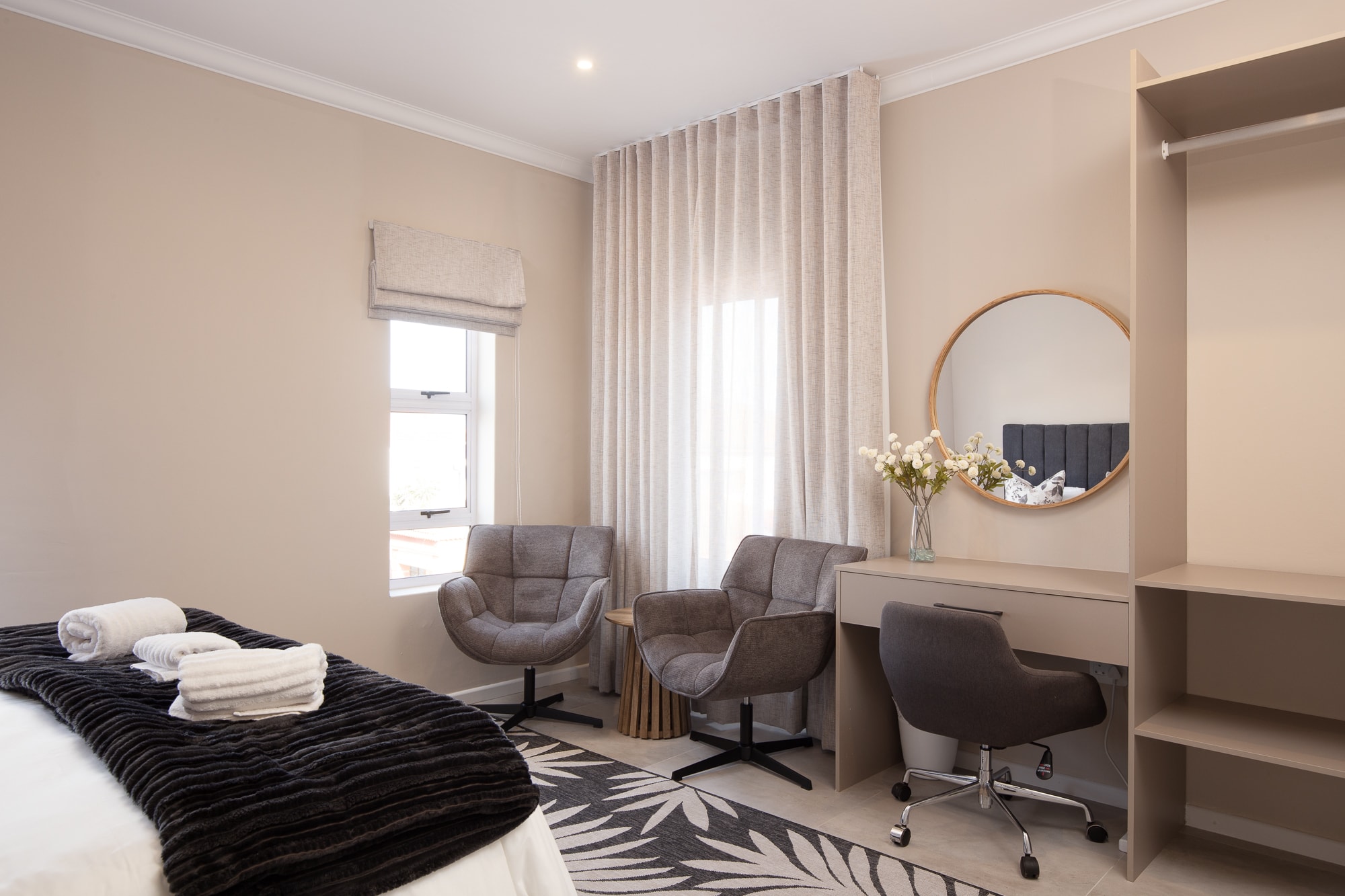 Modern bedroom with seating area and vanity